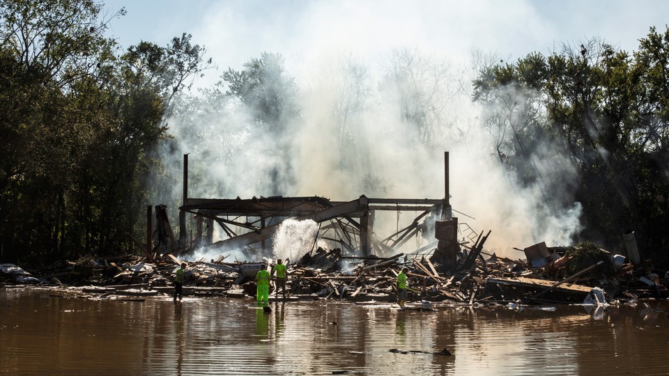 Emergency workers try to douse the smoldering remains of a banquet hall fire after the remnants of Hurricane Ida and its torrential rains tore through the area, in Manville, N.J., Sept. 3, 2021.