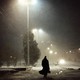 nighttime photo of the back of a man walking down the street