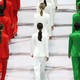 An image from Milan's opening ceremony where models wear suits in red, white, and green, like the Italian flag