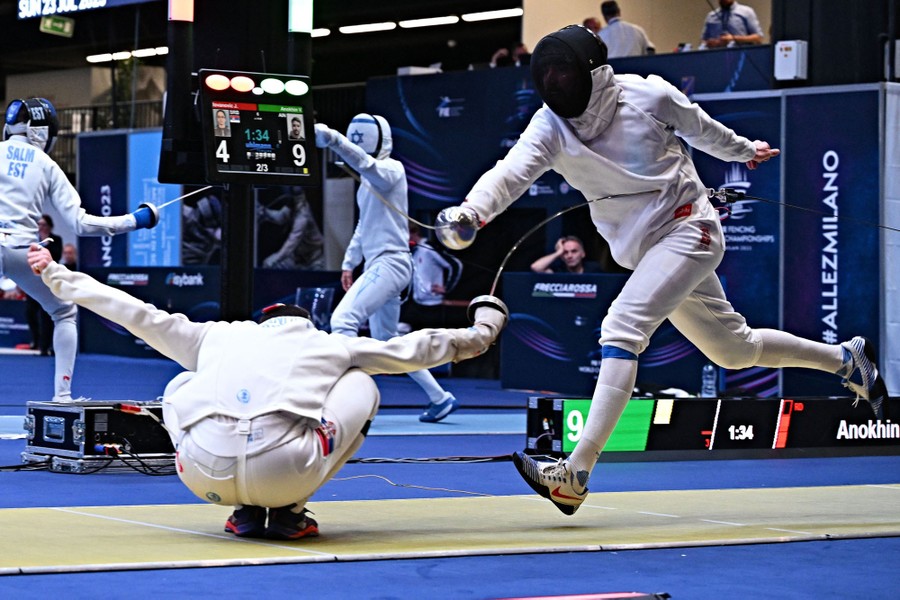 A fencer crouches low, striking his opponent in the torso as he lunges during a match.