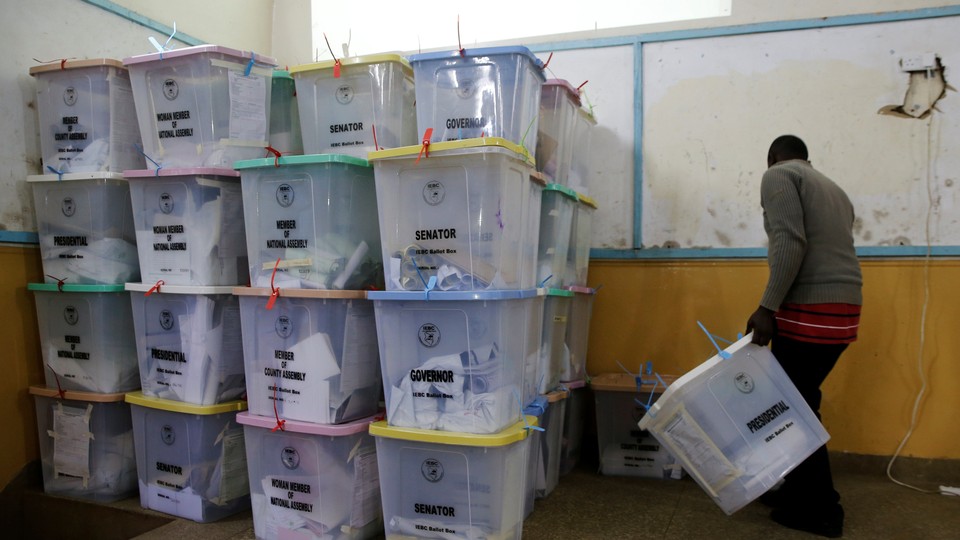 An election official from the Independent Electoral and Boundaries Commission arranges ballot boxes inside the Jamuhuri High School tallying center in Nairobi, Kenya, on August 9.