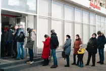 People stand in line to withdraw money from an ATM in Moscow, Russia.