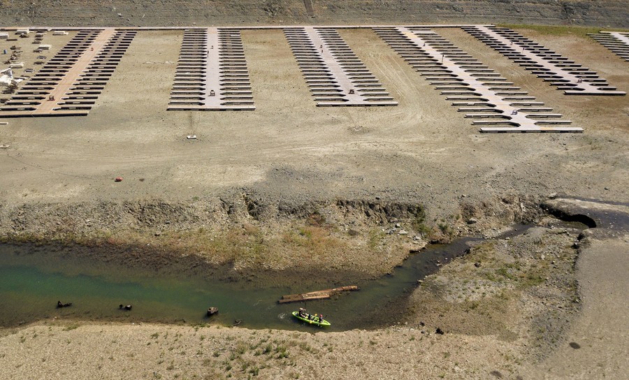 Floating boat docks rest on the dry bed of a low reservoir.