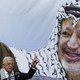 Palestinian President Mahmoud Abbas gestures beneath a poster of the late Palestinian leader Yasser Arafat, during a rally marking the anniversary of Arafat's death in Ramallah on November 11, 2014.