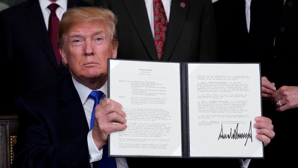 President Trump holds his signed memorandum on intellectual-property tariffs on high-tech goods from China on March 22, 2018.