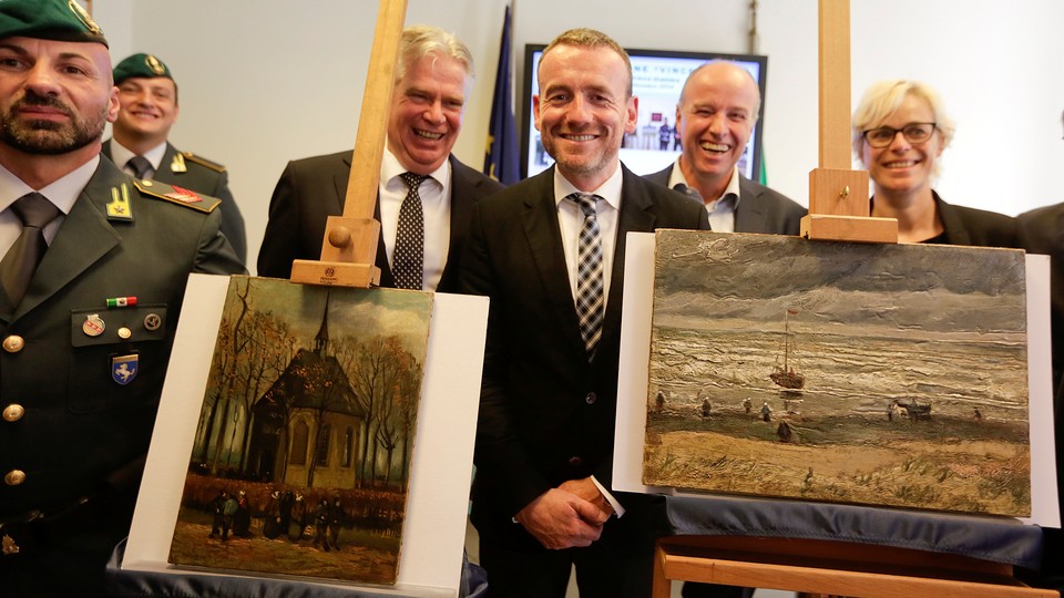 Axel Ruger, the director of the Van Gogh Museum in Amsterdam, poses between the two recovered paintings in Naples, Italy. 