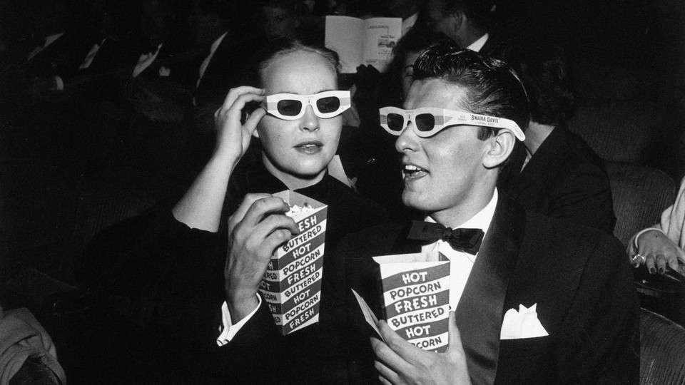 Two moviegoers wearing 3D glasses