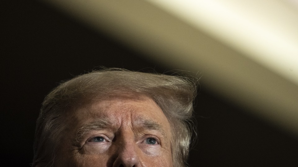 A photo shows the top half of Donald Trump's head at the bottom of the frame