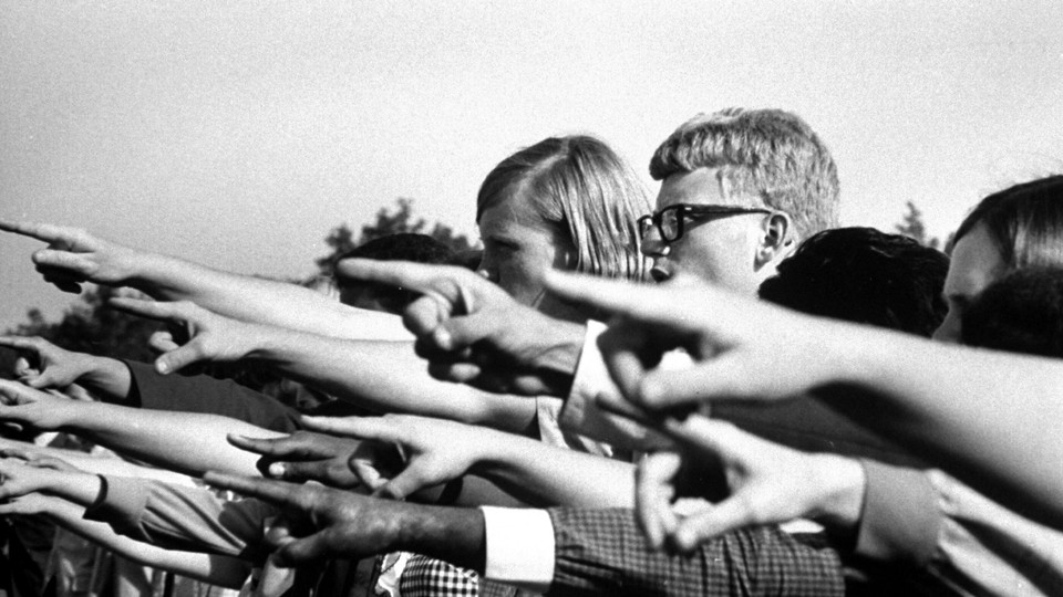 Photo of a crowd of people pointing their fingers in one direction