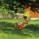 A painting of a woman reading in a backyard under a tree.