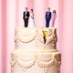 Male-female doll couples (one pair in wedding outfits, the other in evening wear) atop a cracked wedding cake