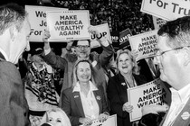 Black-and-white photo of a group of people, most of them holding up signs that say "Make America Wealthy Again"