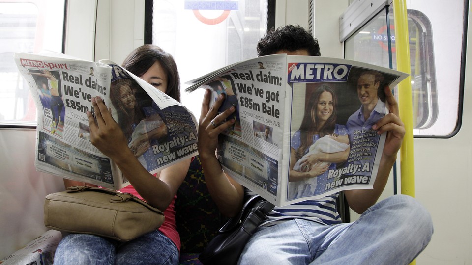 People read newspapers on the London Tube.