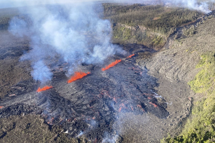 An aerial view of lava flowing through a fissure in the ground