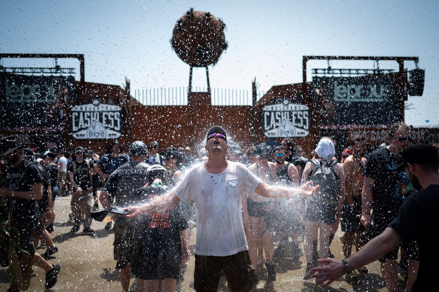 A person is doused with water amid other people at a music festival.