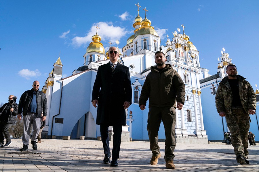 President Joe Biden walks with Ukrainian President Volodymyr Zelenskiy outside a monastery building.