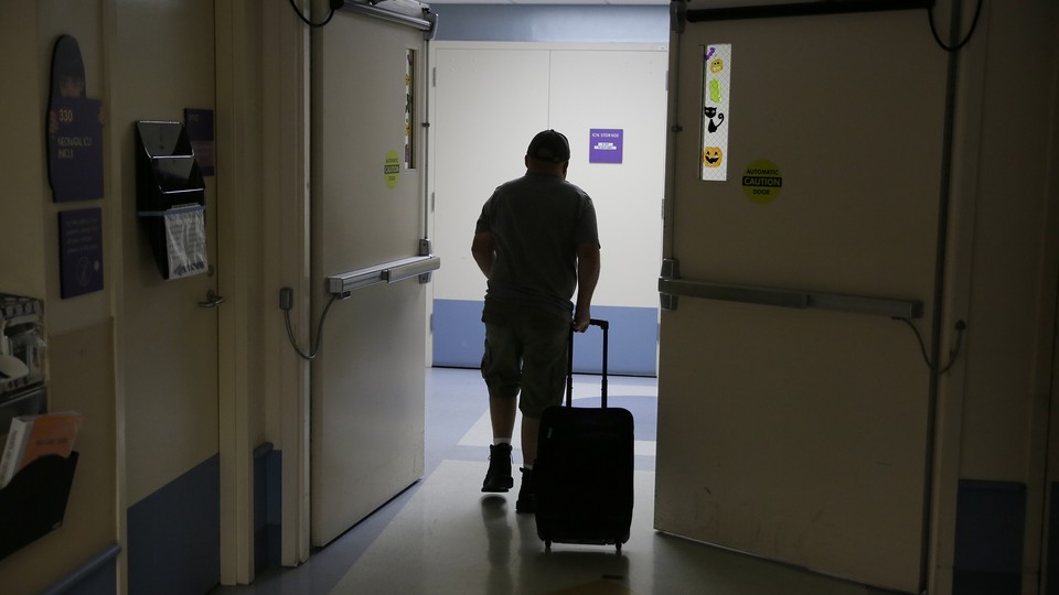 Man walking through hallway with suitcase 