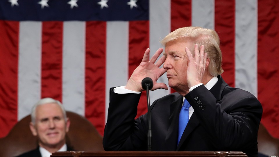 President Donald Trump raises his hands to his head while delivering his first State of the Union address.