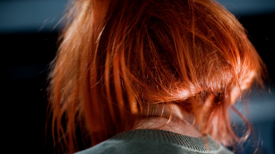 the back of a woman's head; she's wearing a read wig