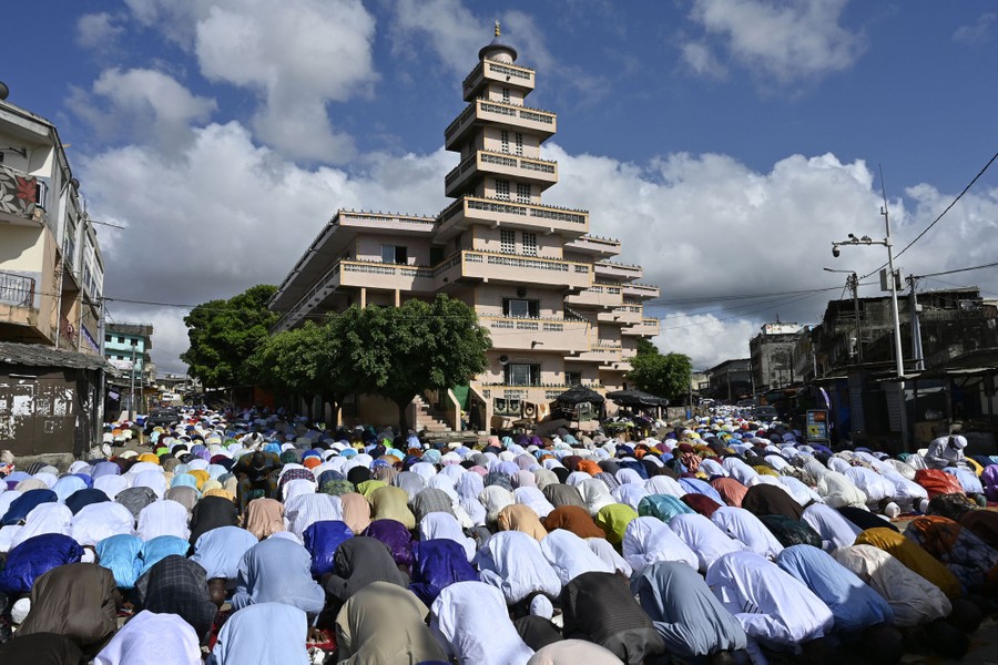 A large group of people pray together.