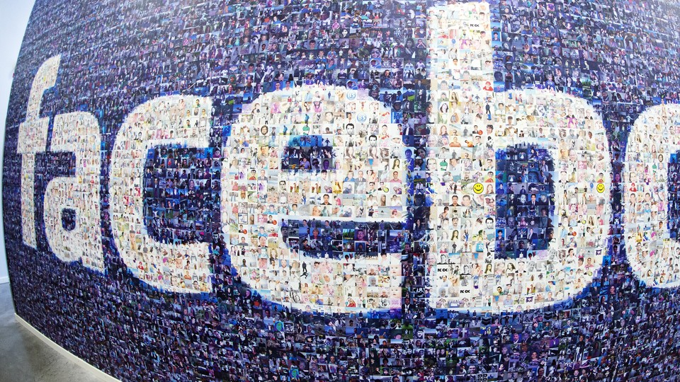 A wide-angle photograph of a wall plastered with the Facebook logo made of smaller photos