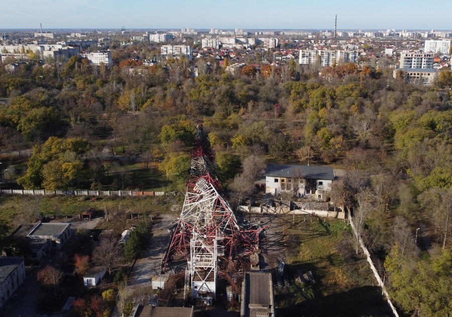 An aerial view of a toppled red-and-white broadcast tower