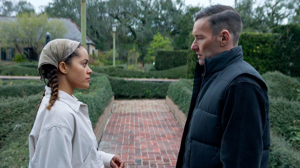 Quintessa Swindell and Joel Edgerton stare at each other while standing in a garden, in "Master Gardener."