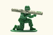 Artwork of a toy soldier wielding a rocket launcher made of a $100 bill