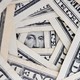 A vortex of dollar bills with George Washington's face at the bottom