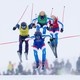 Four ski racers, seen in midair, jumping during a race