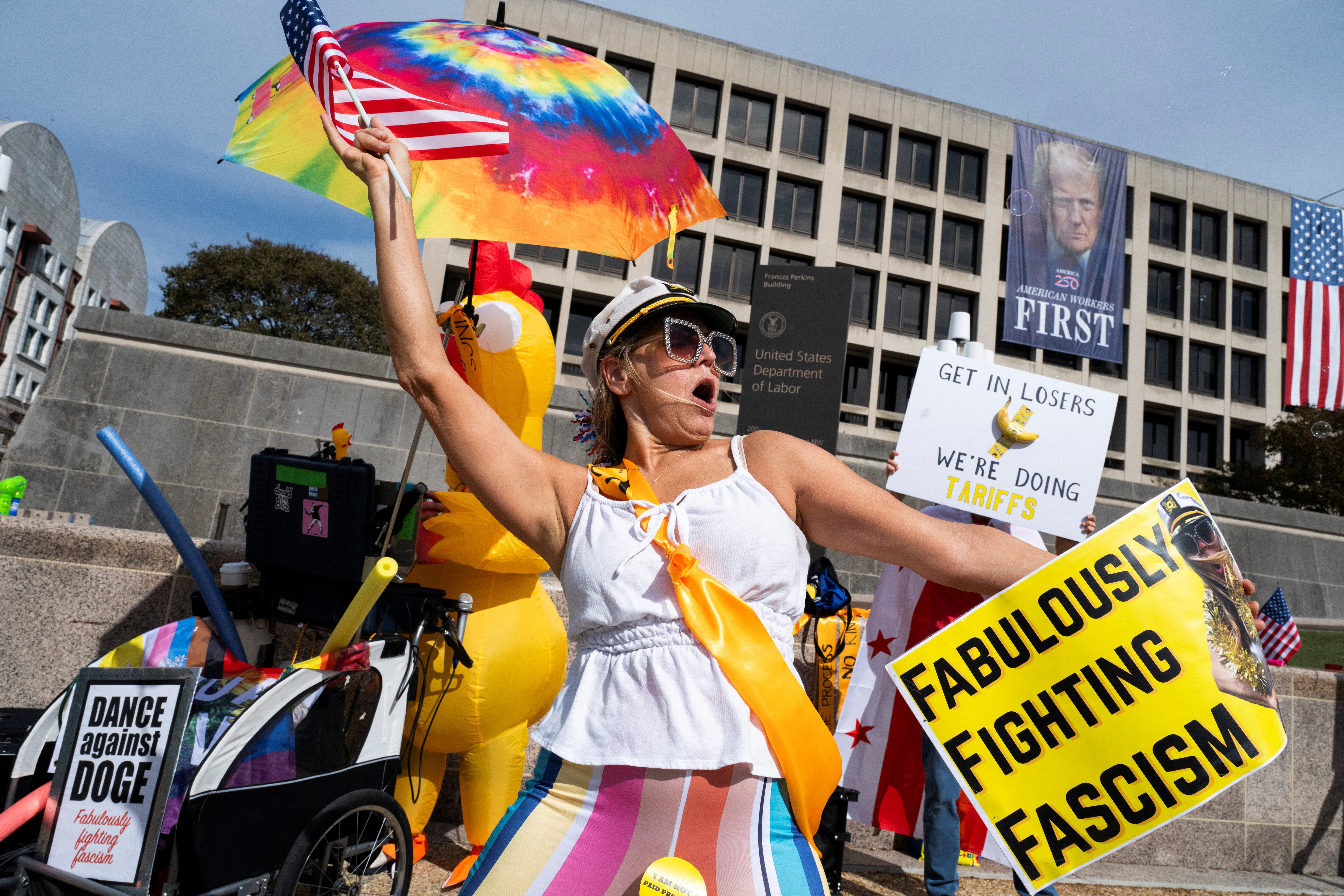 A protester waves a flag, while holding a sign that reads