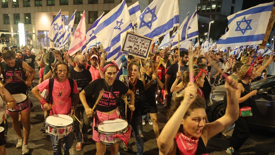 Demonstrators wave the flag of Israel during a march against the government's judicial reform plan in Tel Aviv