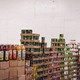 A worker stacks canned food inside a food distribution center