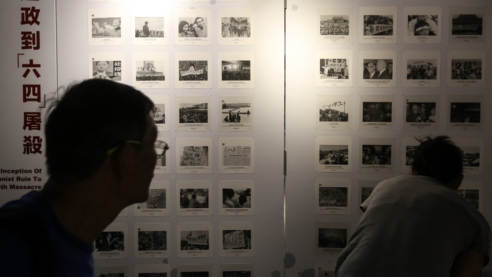 Visitors look at photographs at the June 4 Museum in Hong Kong during its reopening event in April.
