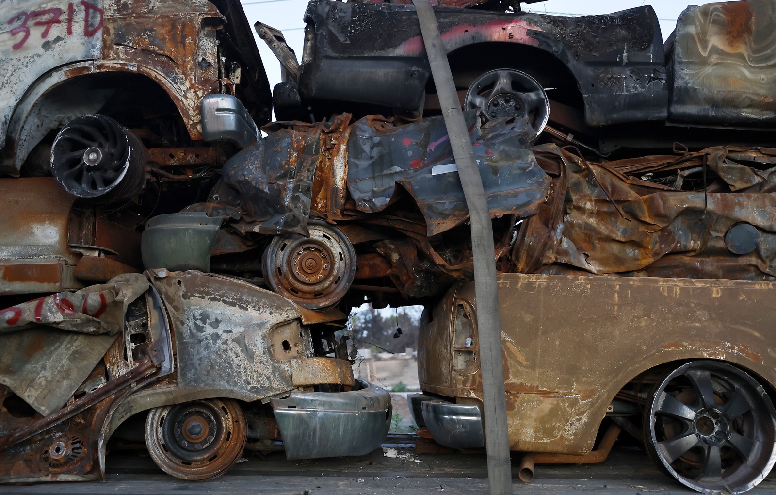 A close view of a stack of several burned-out vehicles
