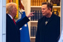 Color photograph of Donald Trump gesturing his left hand toward Elon Musk as they stand talking.