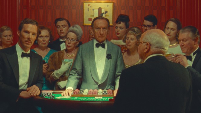 A group of people surround a gambling table