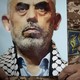 An IRGC member holds a poster of Sinwar