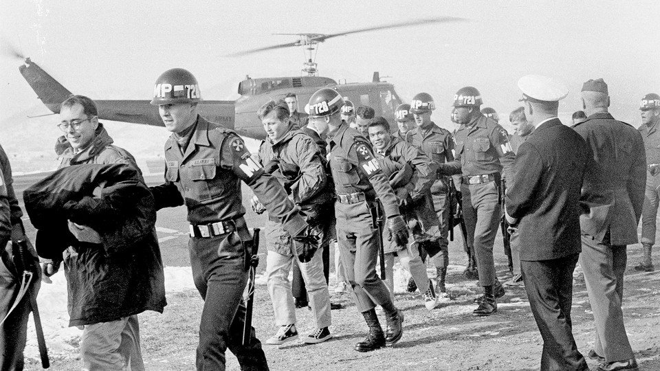 Released crewmen of the USS Pueblo are escorted by MPs off a helicopter.