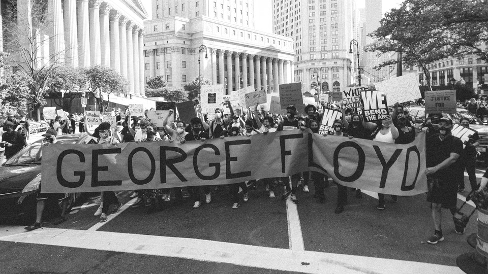 photo of protesters with 'George Floyd' banner