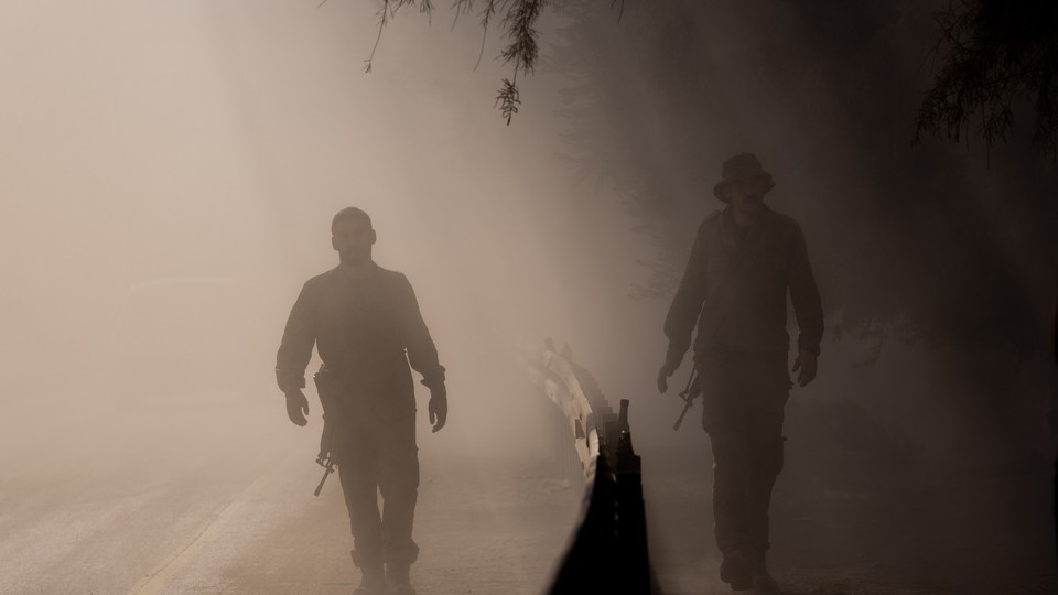 Two soldiers walk on a hazy dusty road