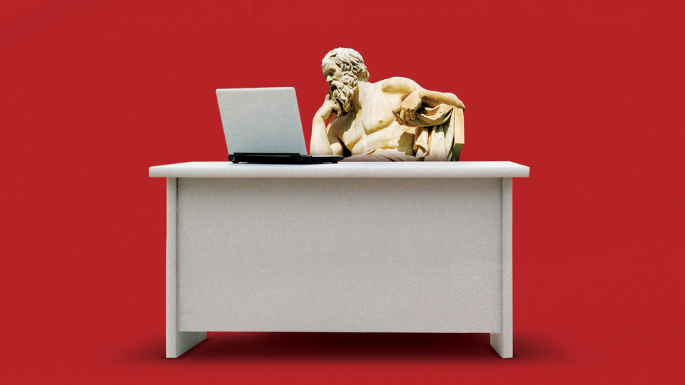 A statue of Socrates sits at a desk and ponders a laptop.