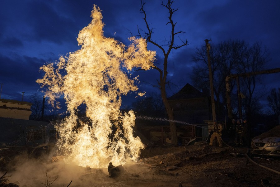 A rescue worker puts out a fire after a missile strike.