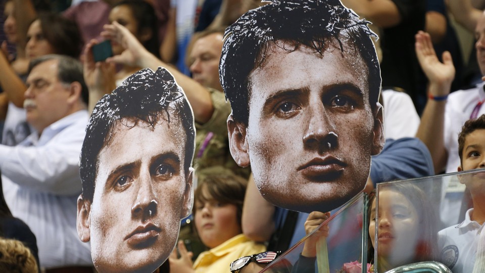 Fans at the 2012 London Olympics hold cutouts of U.S. Olympic swimmer Ryan Lochte.