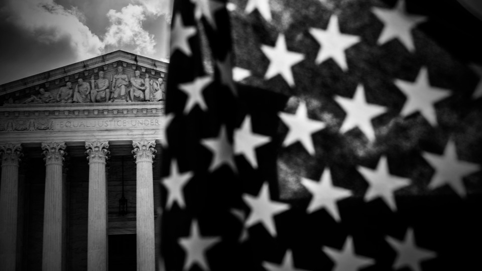 A photo showing an American flag in the foreground and the Supreme Court in the background