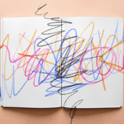 A coloring book covered in multicolor scribbles, as if from crayons