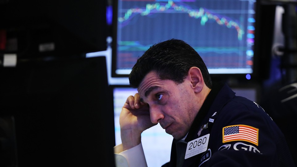 A stock trader looks at a computer screen