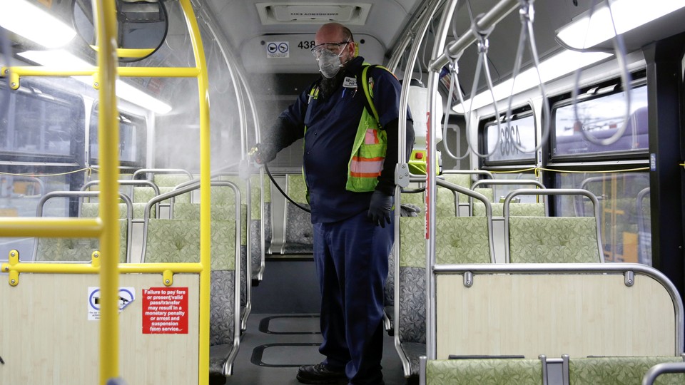 A King County Metro equipment service worker sanitizes a bus.