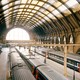 A picture showing the platform of King's Cross train station, in London, daylight radiating from one of the windows.