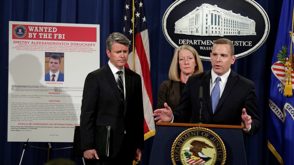 Paul Abbate, the–then FBI assistant director of the Criminal, Cyber, Response, and Services Branch, speaks next to a poster of a suspected Russian hacker in 2017.